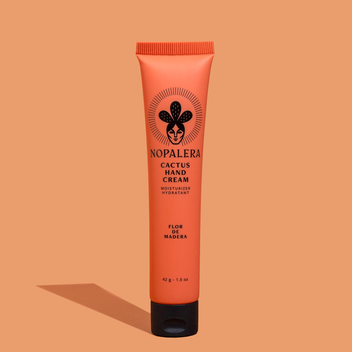 Tube of Nopalera Cactus Hand Cream  Flor de Madera with a peach-colored background, featuring the product name and an illustration of a cactus.