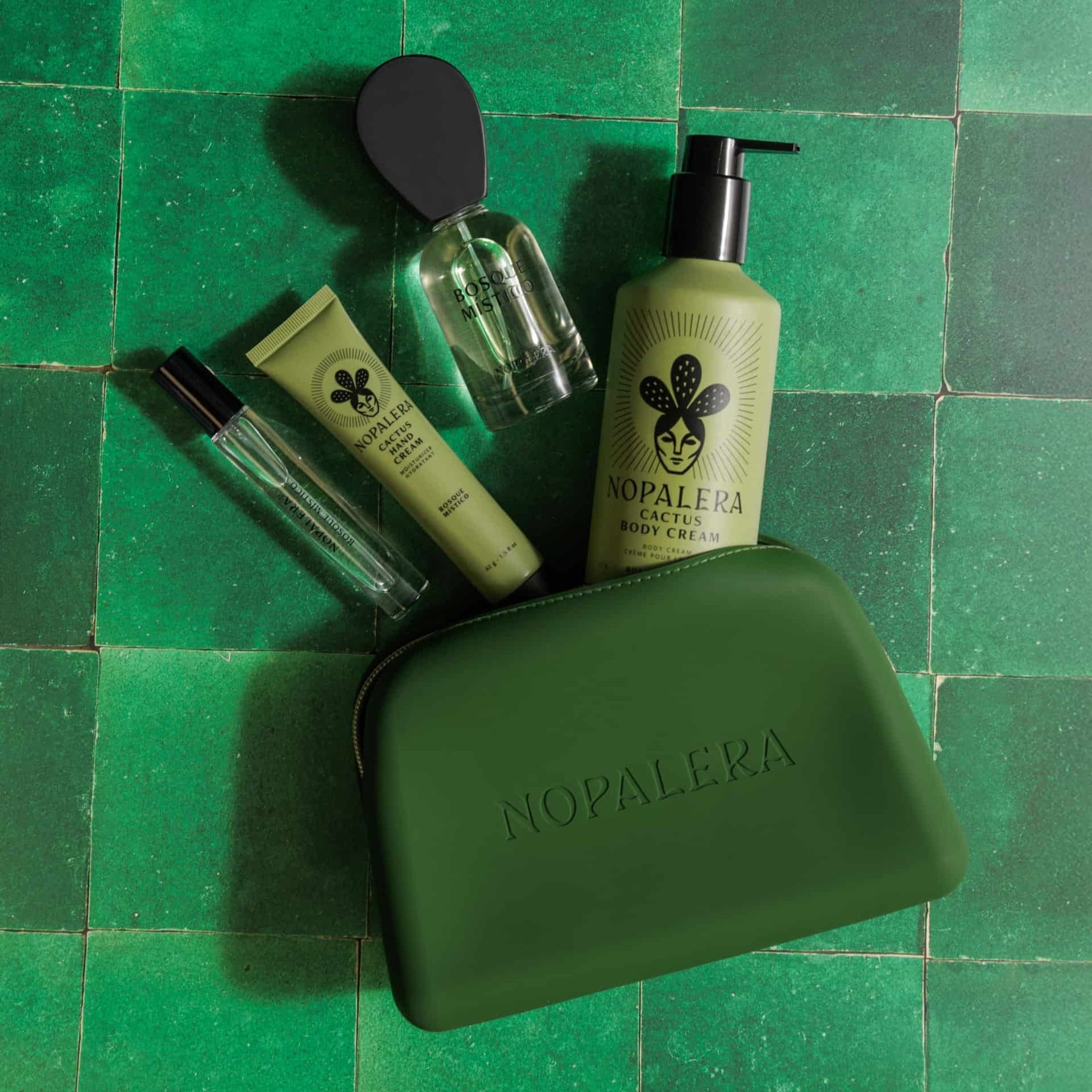 Nopalera skincare products on a green tiled background and a Green nopalera.sbssmetic pouch with gold zipper and embossed logo 