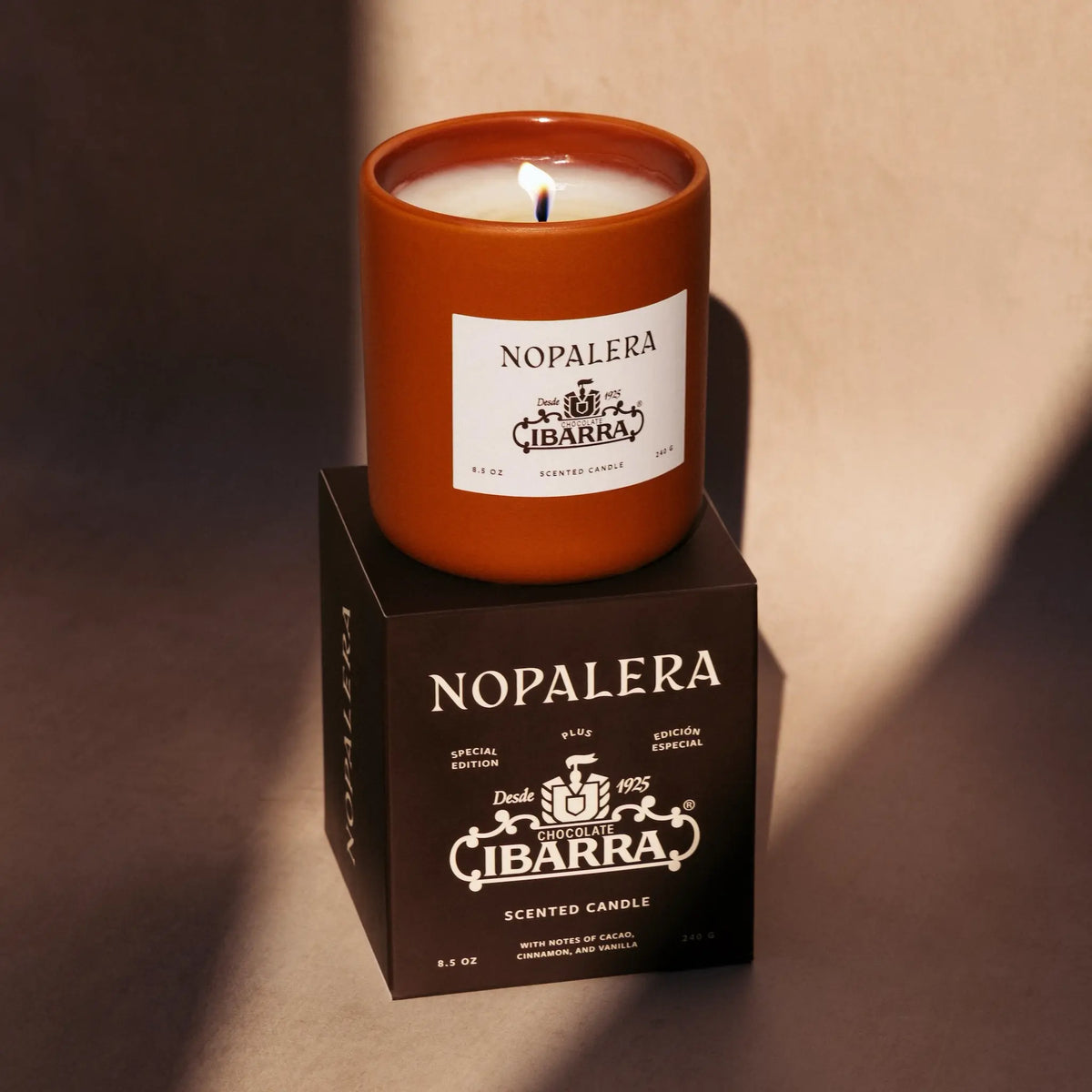 Nopalera Ibarra scented candle on a matching box with a warm glow.